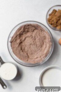Dry ingredients for chocolate cake in a glass bowl.