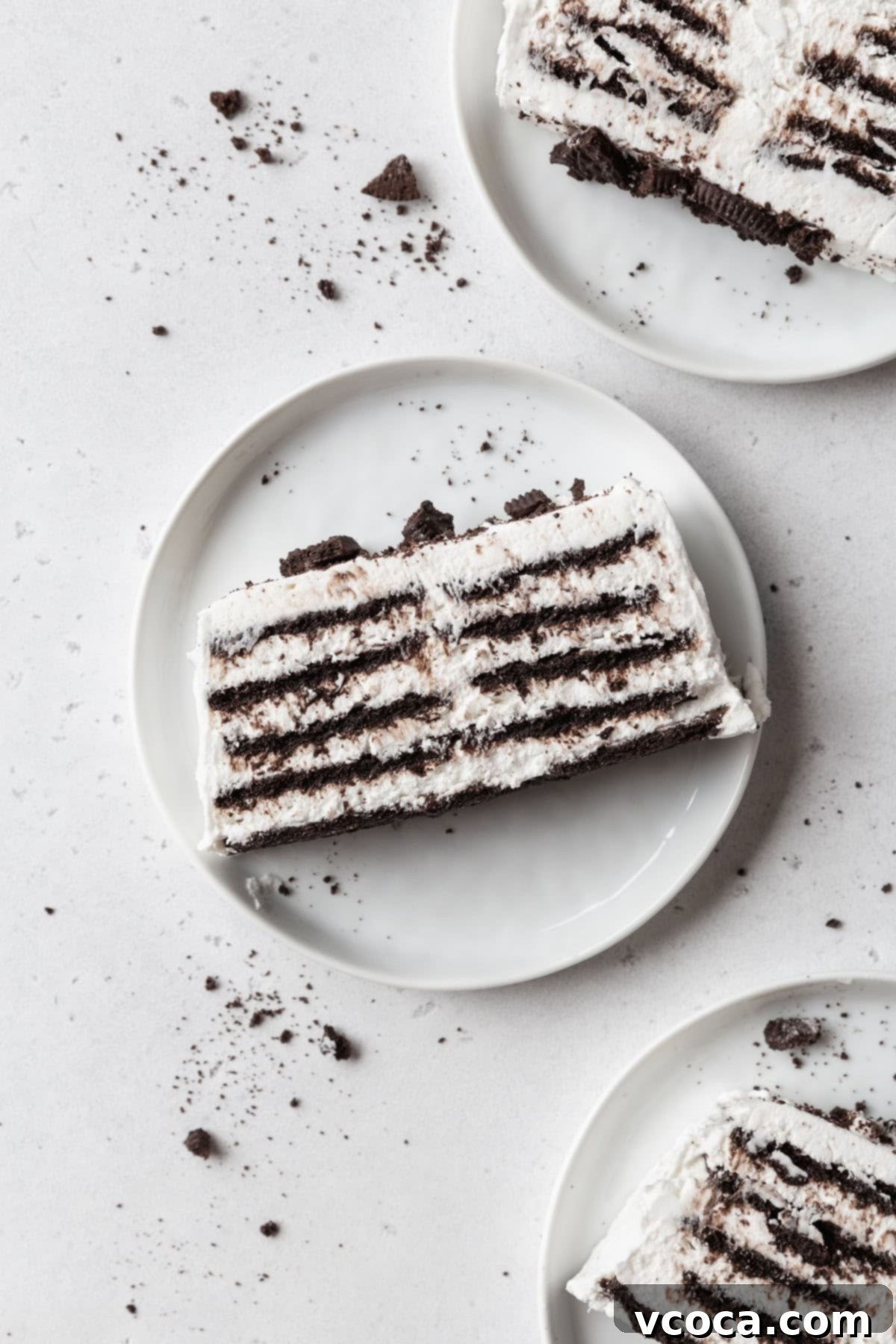 No-Bake Cloud Layers 2 Three slices of icebox cake on white plates on a light grey surface.