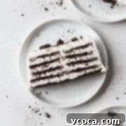 No-Bake Cloud Layers 4 A slice of icebox cake on a white plate with Oreo crumbs.