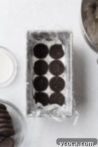 Chocolate cookies in a loaf pan with cream underneath.