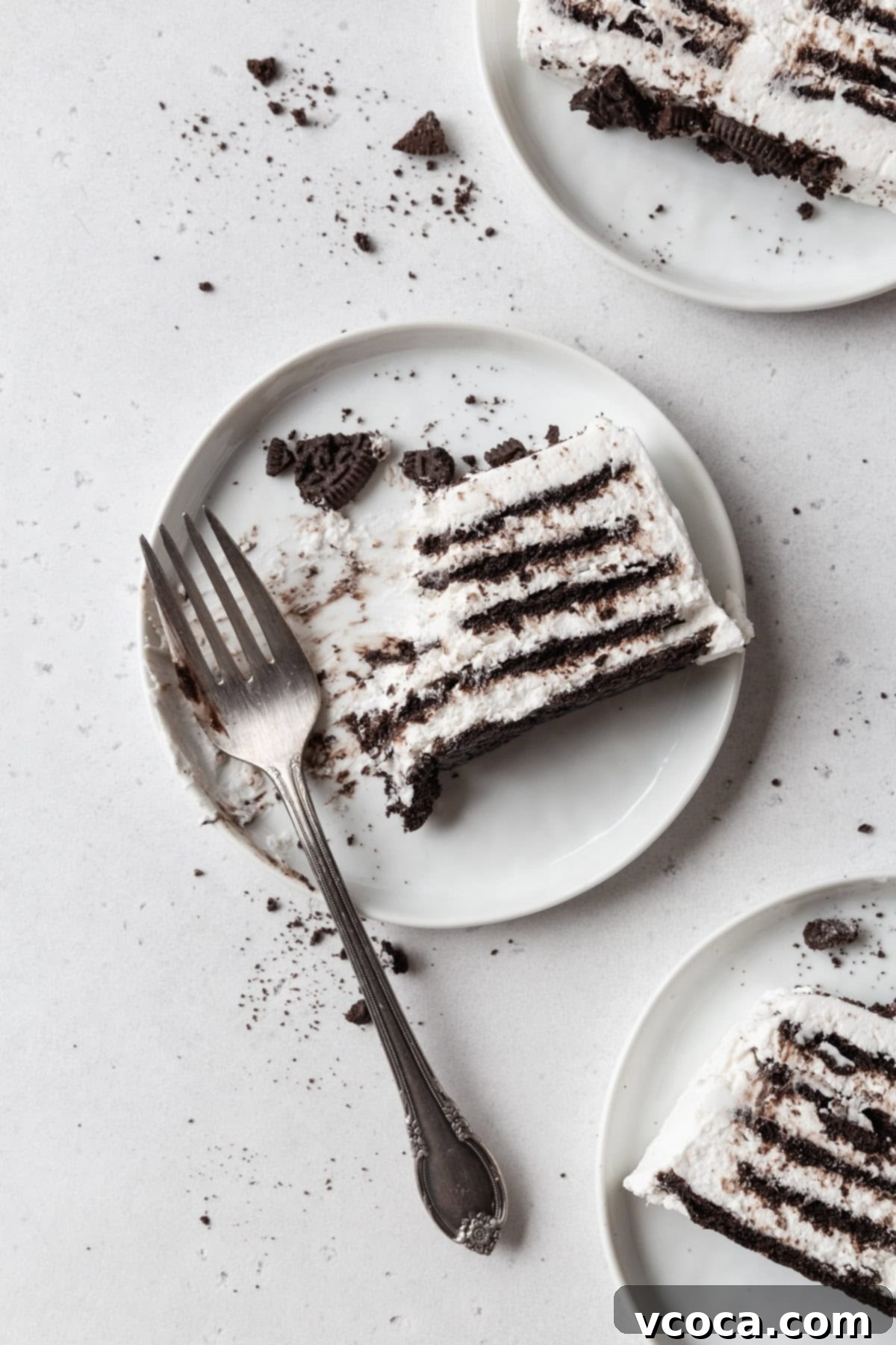 No-Bake Cloud Layers 9 A partially eaten slice of icebox cake on a white plate with a fork.