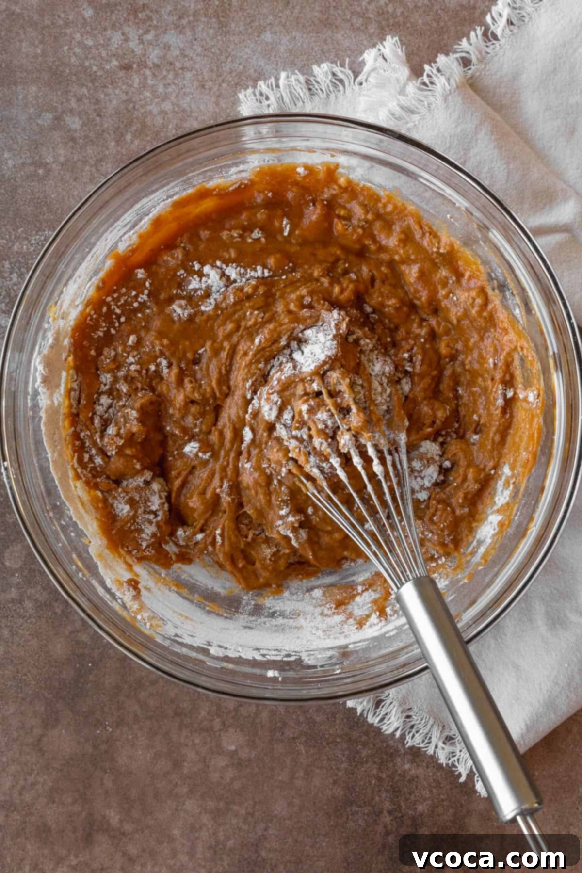 Whisking together gluten free pumpkin muffin batter.