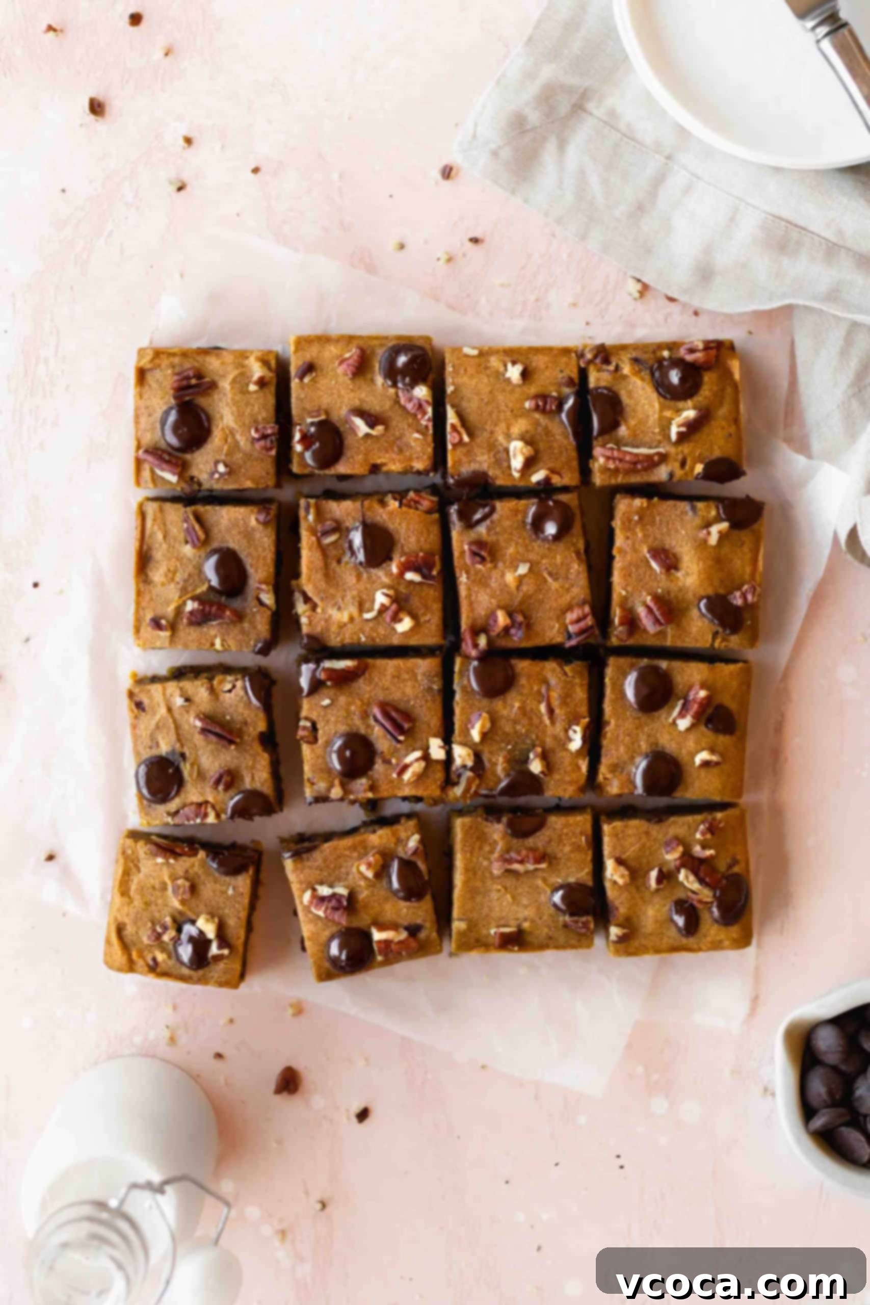 Pumpkin blondies cut into squares, showcasing a fudgy texture with visible chocolate chips and pecans.