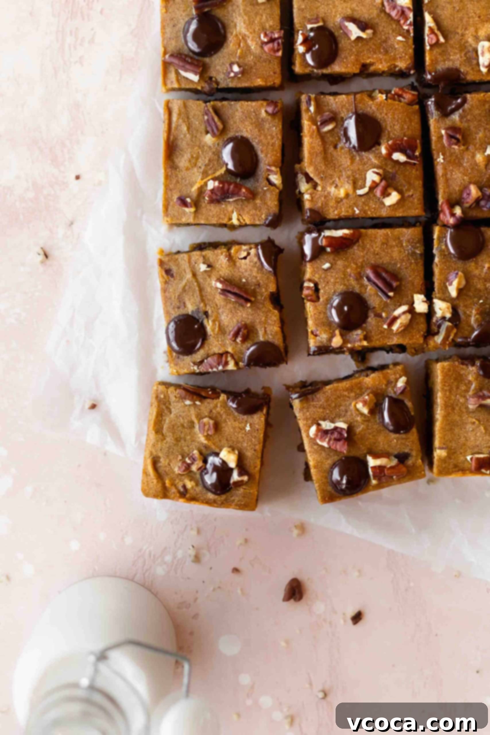 Close-up of golden pumpkin spice blondies with chocolate chips and pecans, still in the baking pan.