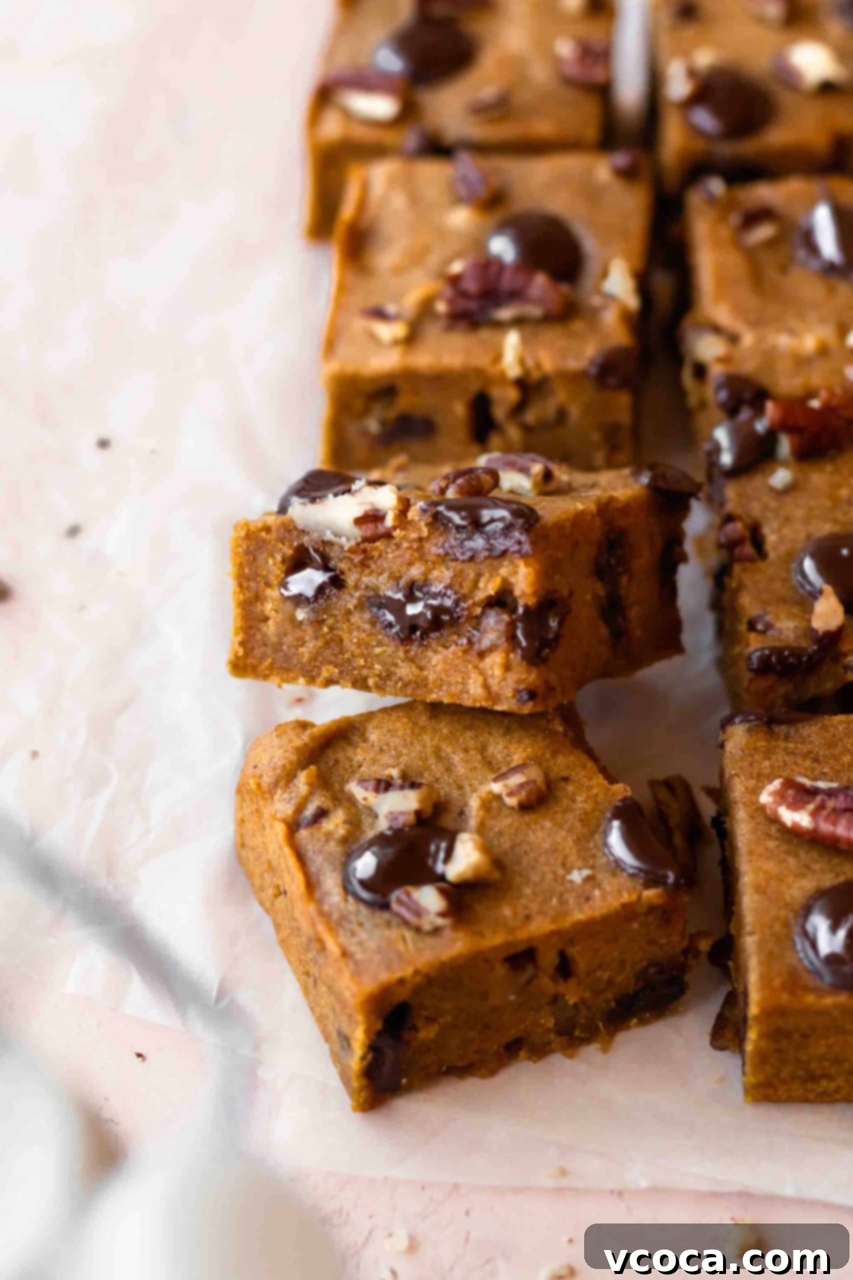 Top-down shot of baked pumpkin spice blondies with chocolate chips, ready for slicing.