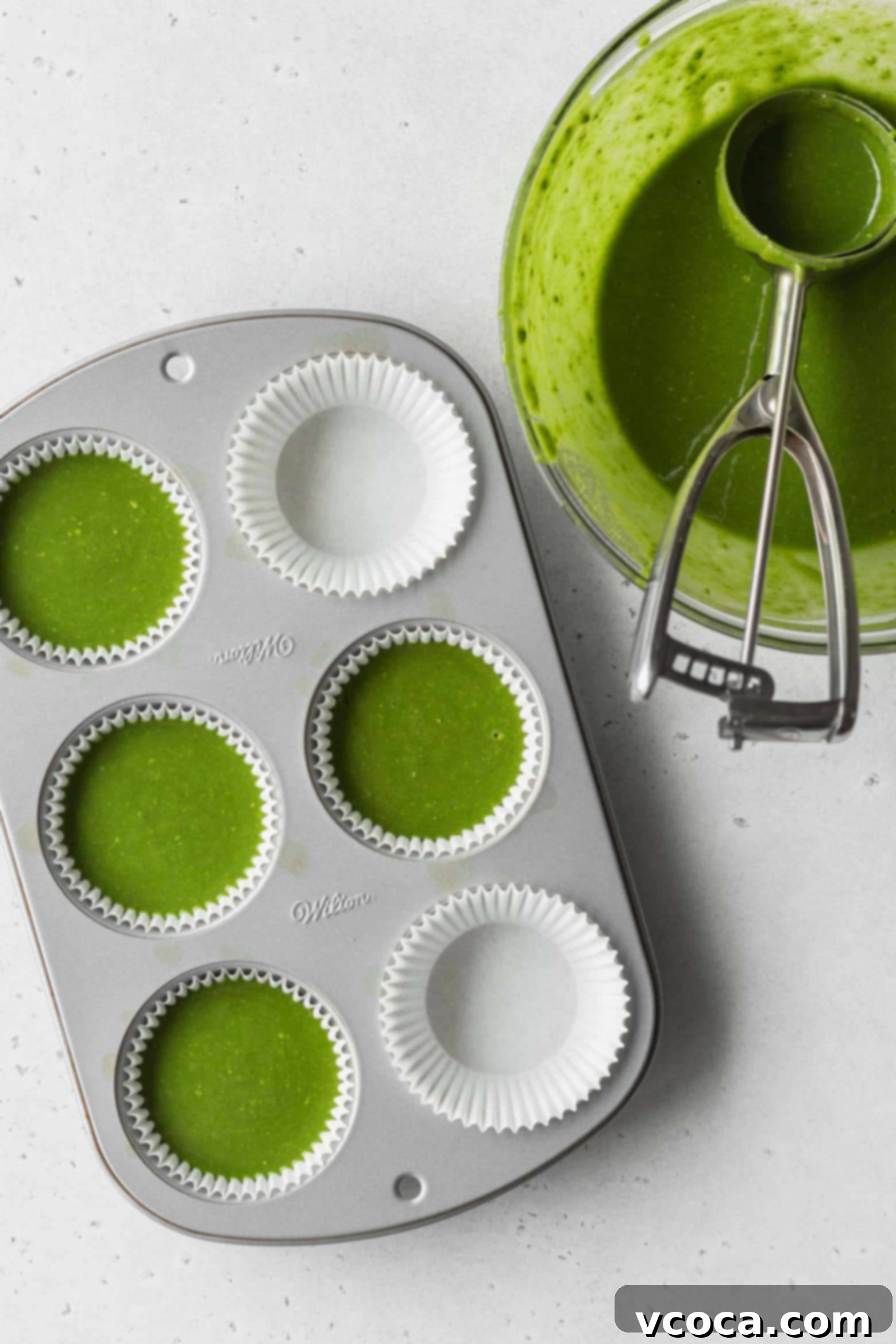 Pour the matcha cake batter into the muffin pan using an ice cream scoop