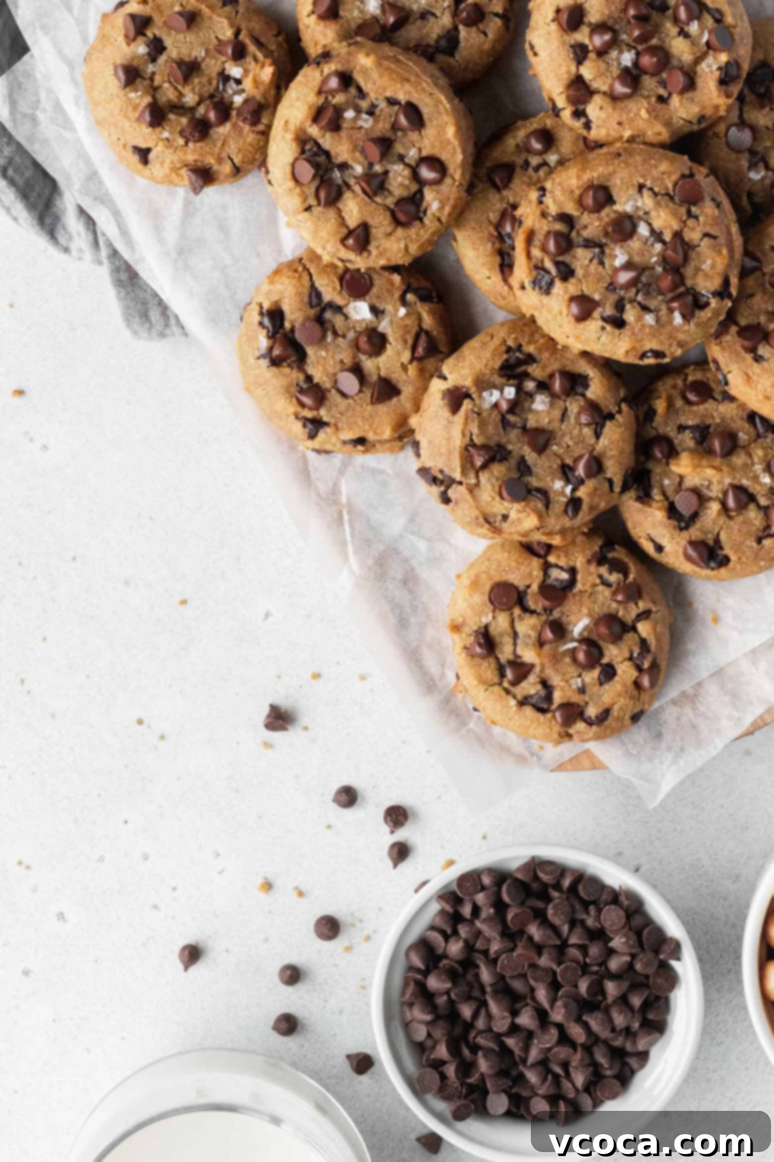 Several gluten-free chocolate chip chickpea cookies arranged appealingly on parchment paper.