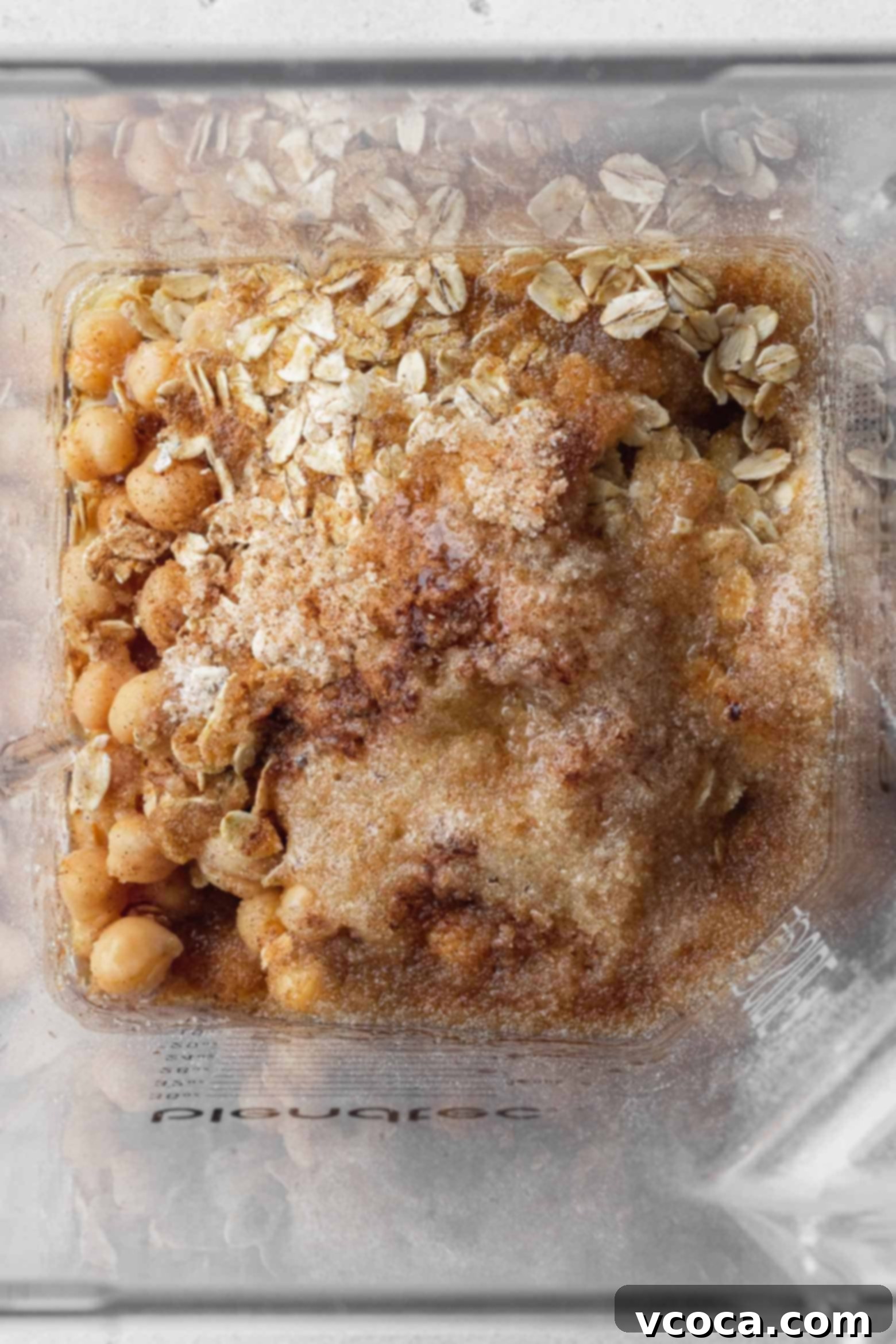 Close-up of chickpea cookie ingredients being added to a blender, prior to mixing.