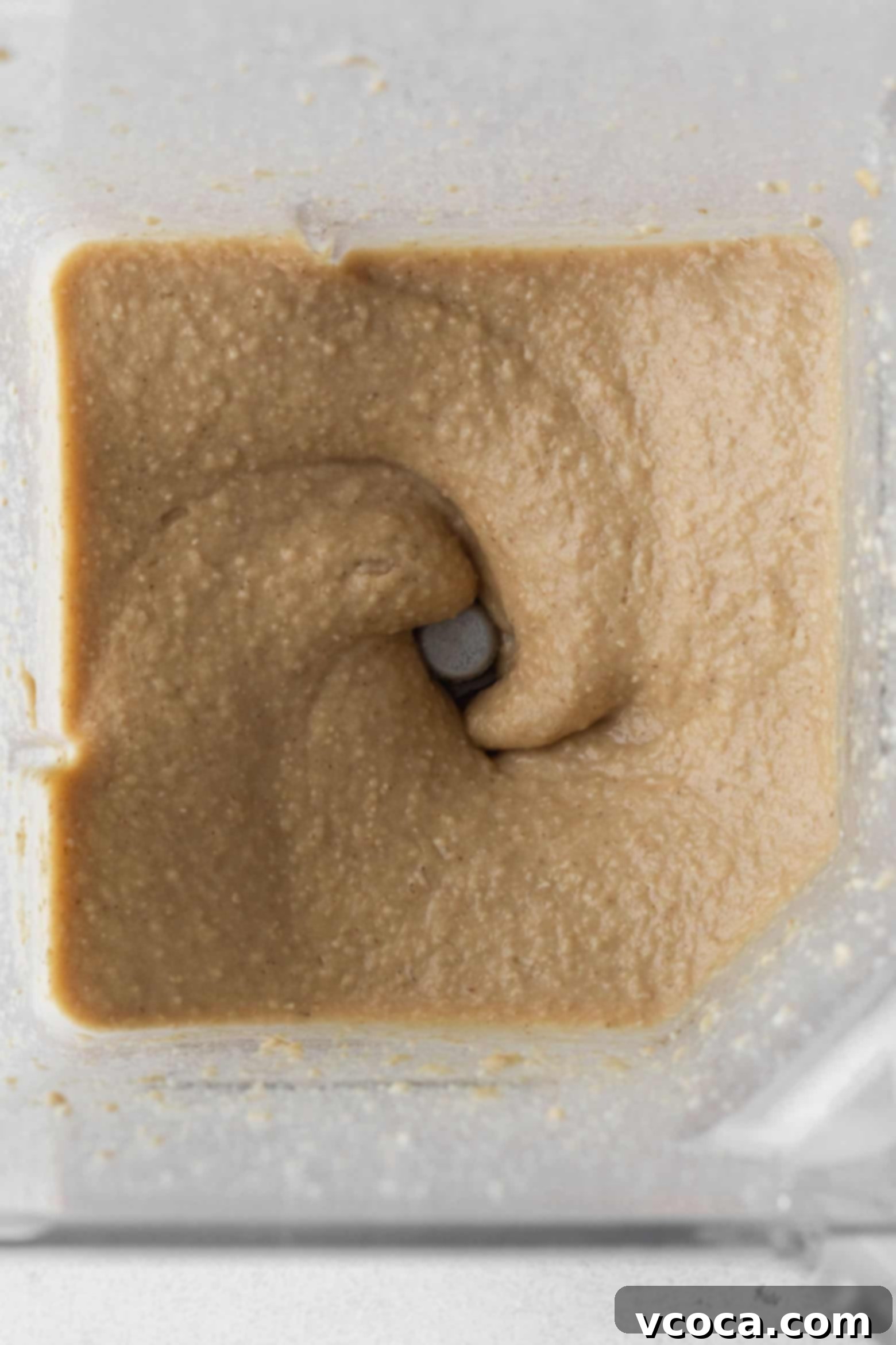 Close-up of the chickpea cookie dough in a blender, showing its smooth consistency.