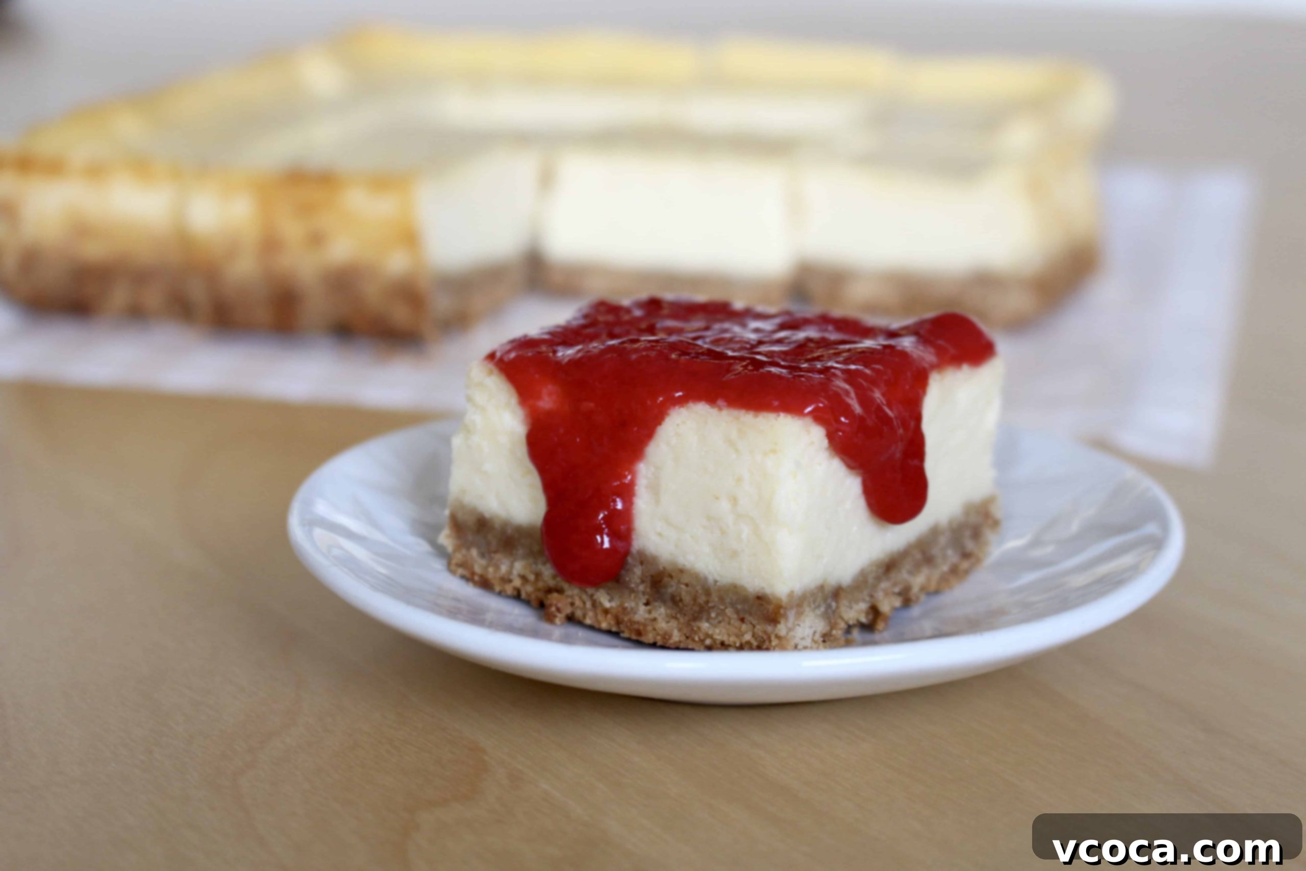Fifteen cheesecake bars neatly arranged on a plate, ready for serving
