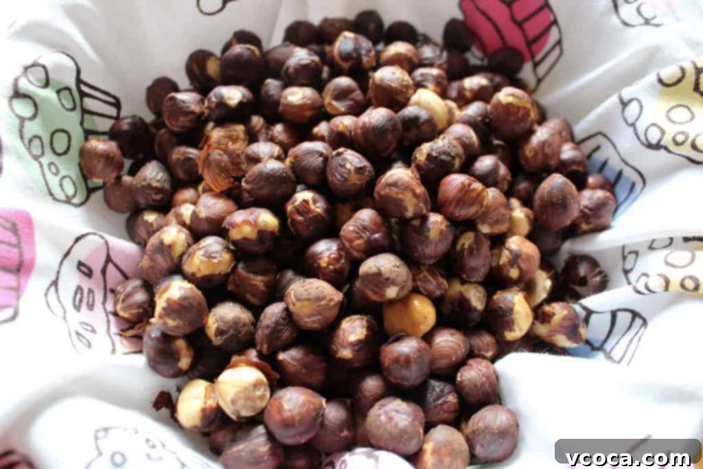 Raw hazelnuts arranged on a baking sheet and placed into a hot oven.