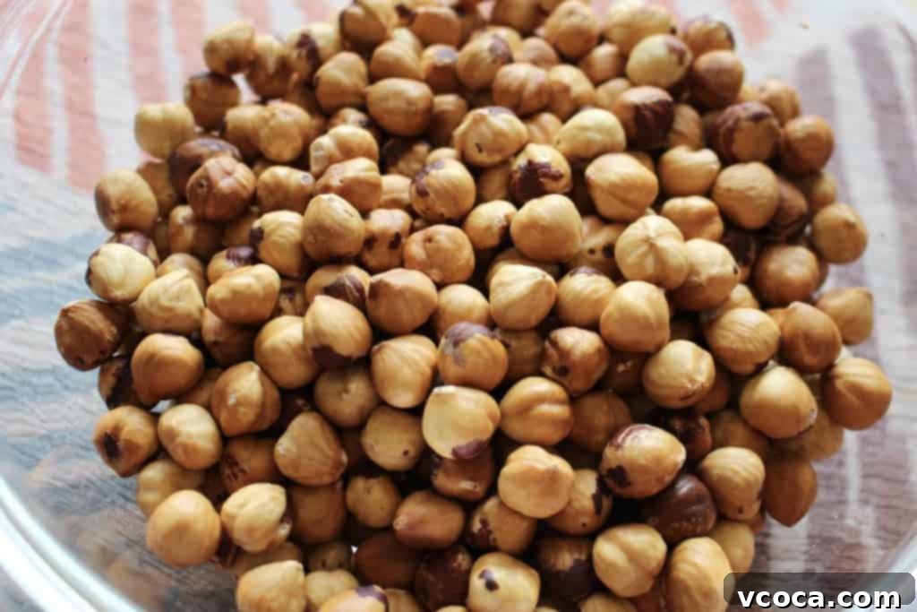Perfectly roasted and peeled hazelnuts, some lightly salted, showcasing their smooth texture.