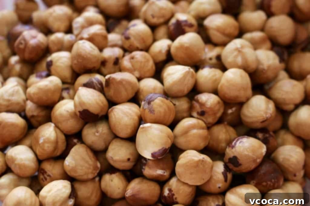 A bowl filled with perfectly roasted and peeled hazelnuts, ready for enjoyment.