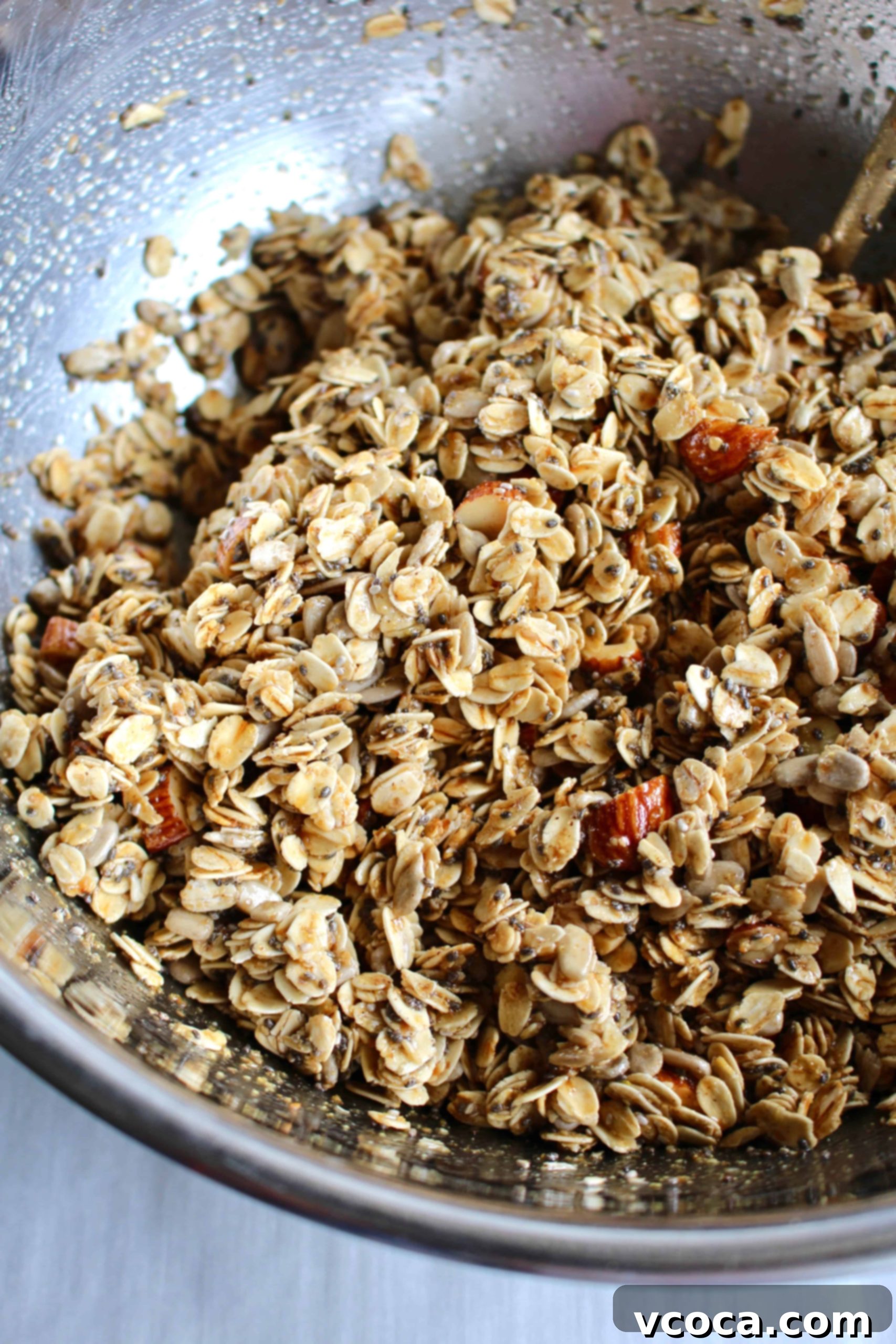 Seriously Delicious Gluten-Free Granola 4 Gluten-free granola ingredients mixed in a metal bowl.