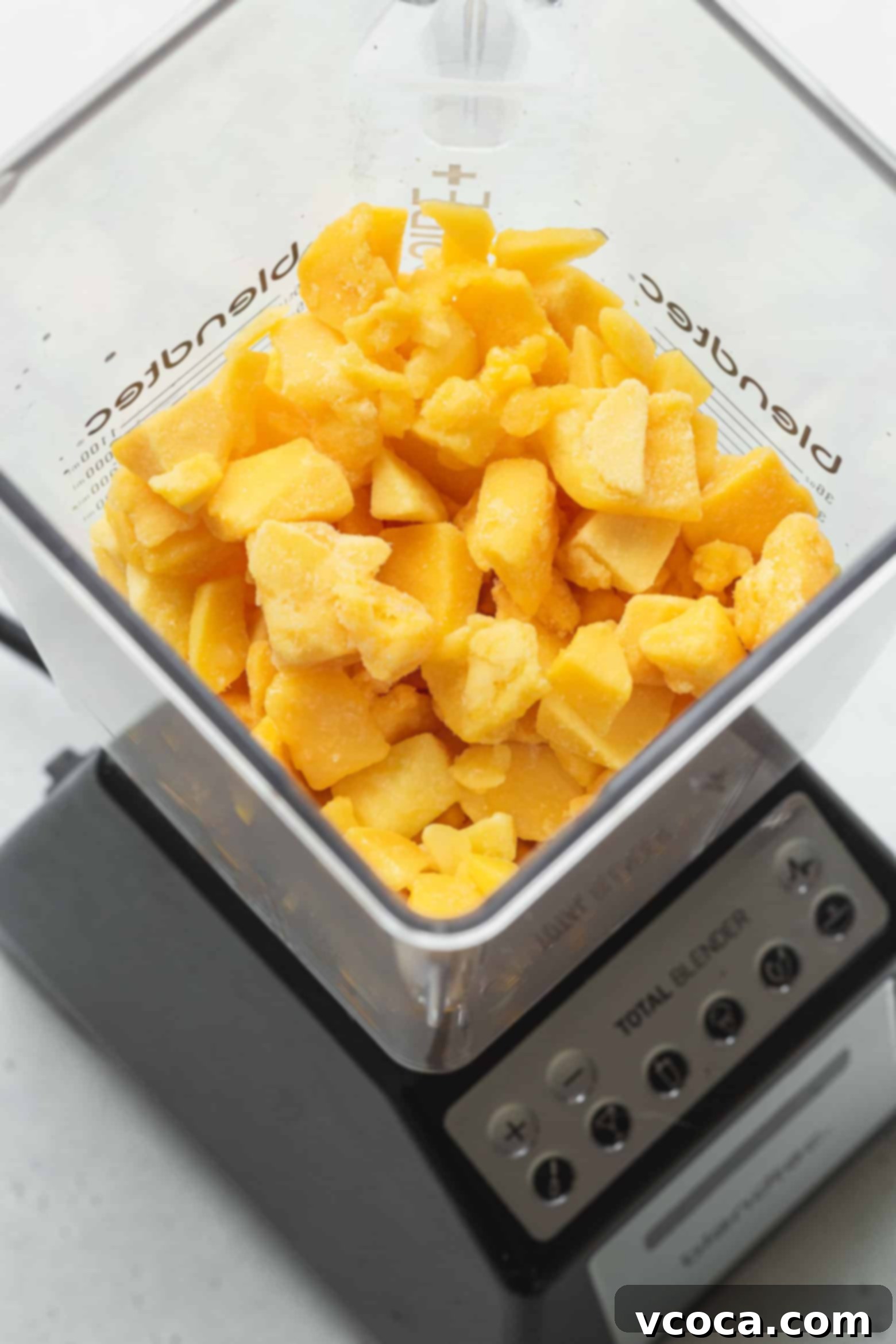 Easy Two Ingredient Mango Sorbet 4 Frozen mango cubes being added to a food processor, ready for blending into a delicious sorbet