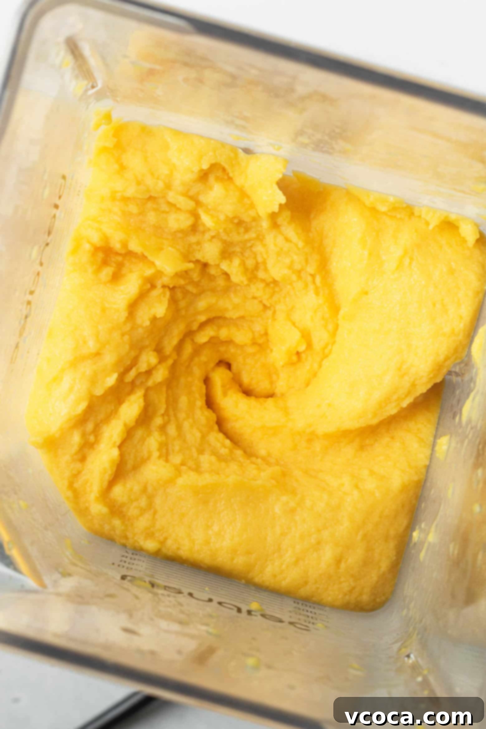 Easy Two Ingredient Mango Sorbet 5 Smooth, creamy blended mango sorbet swirling in a food processor, showcasing its perfect, ready-to-serve consistency