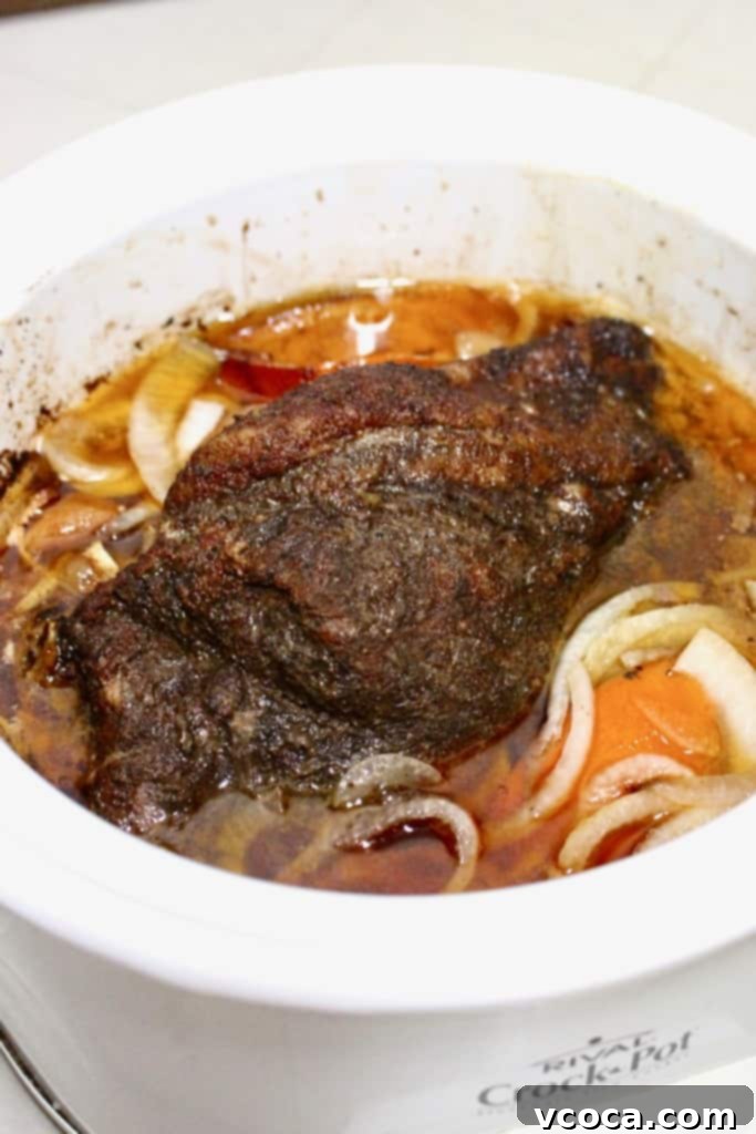 Carnitas cooking in a crock pot.