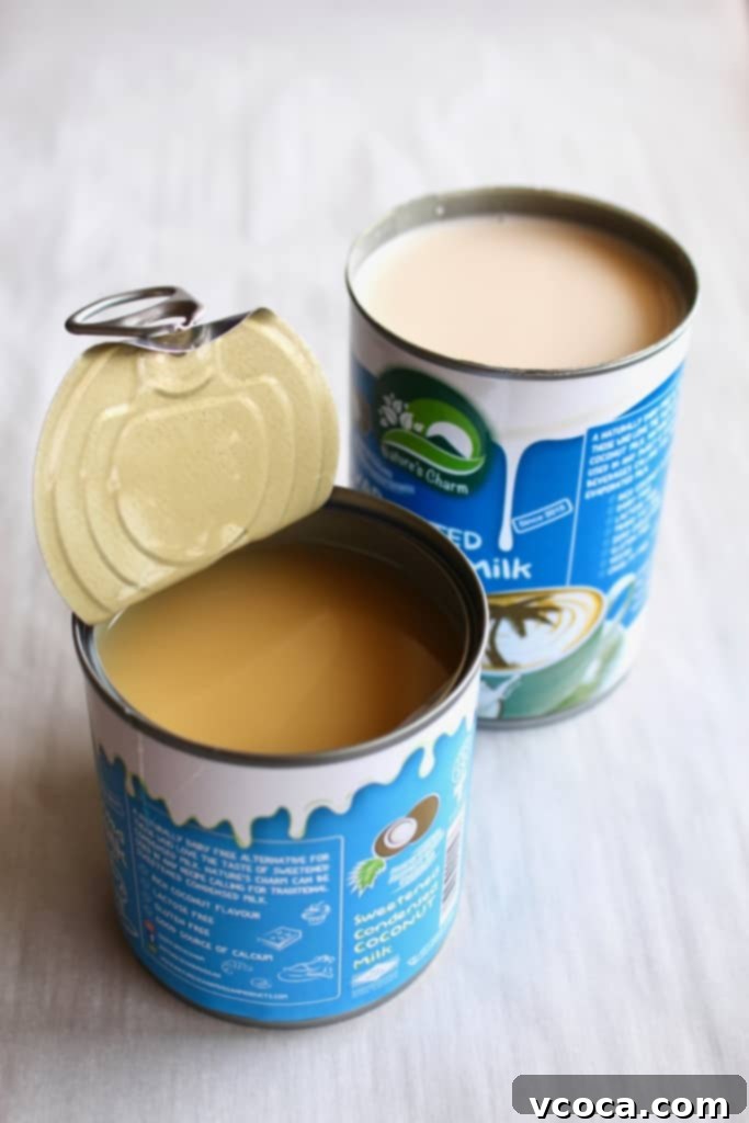 Opened cans of Nature's Charm condensed coconut milk and evaporated coconut milk, showing their creamy texture