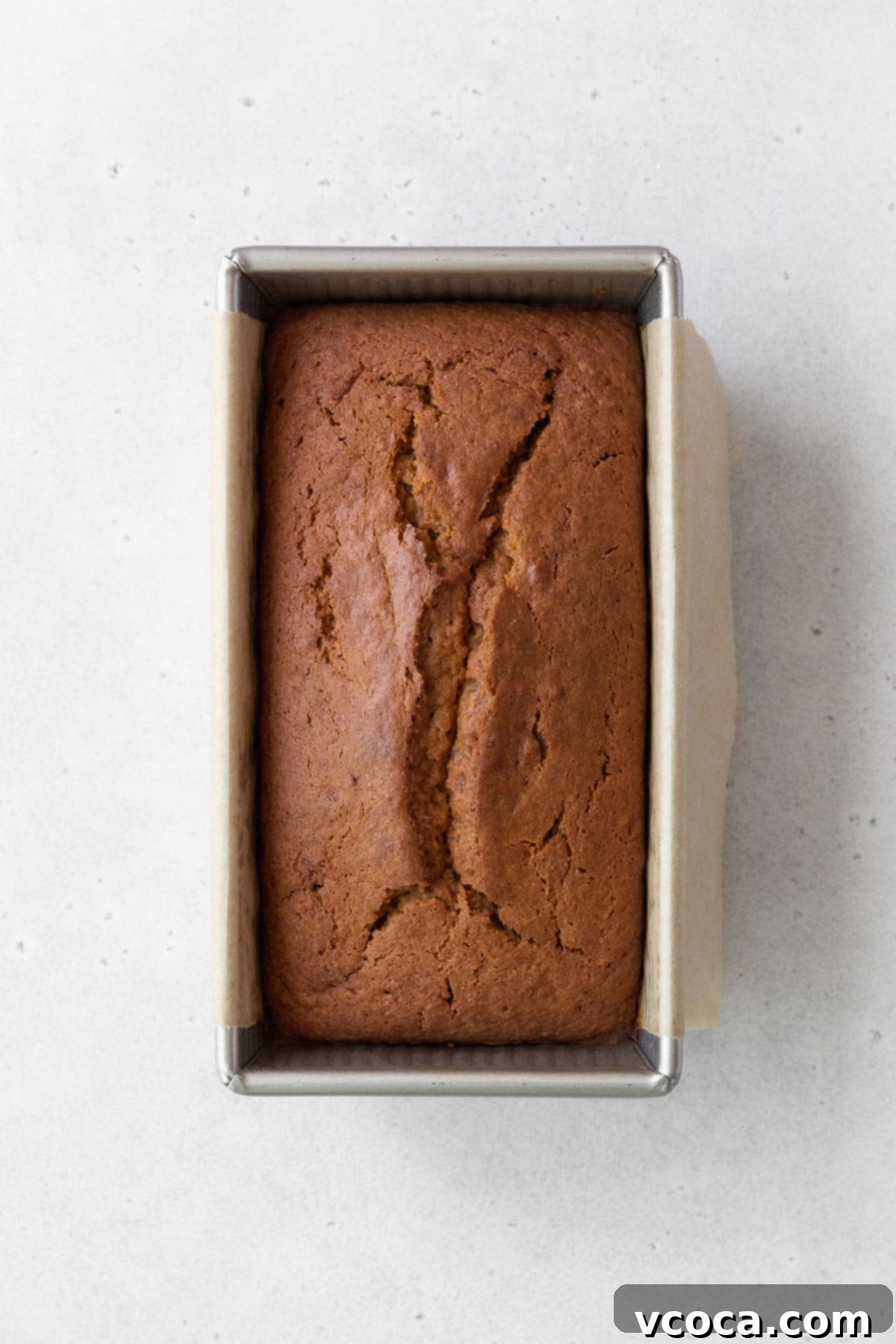 Spiced Sweet Potato Cake with Cashew Frosting 14 Overhead shot of a baked sweet potato loaf cake in a metallic pan.