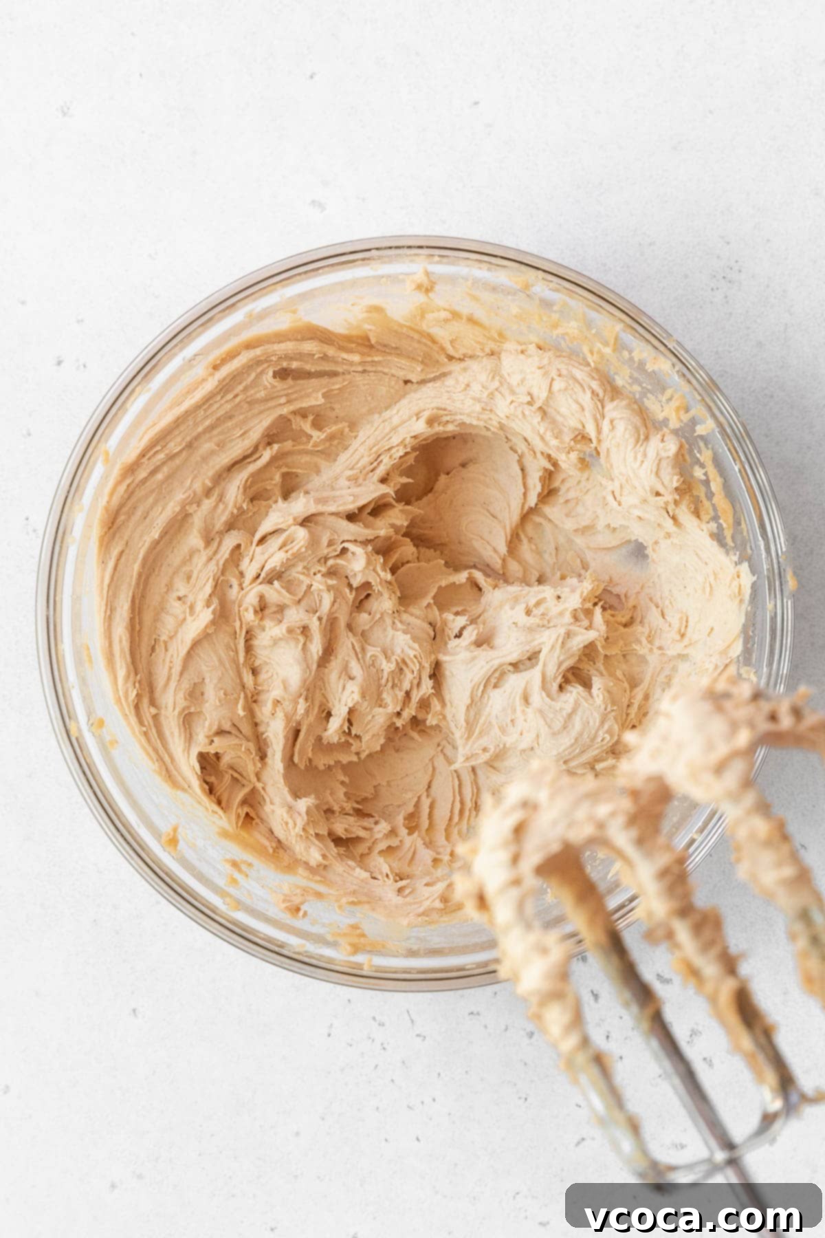 Spiced Sweet Potato Cake with Cashew Frosting 17 A glass bowl of cashew frosting whipped with a hand mixer.