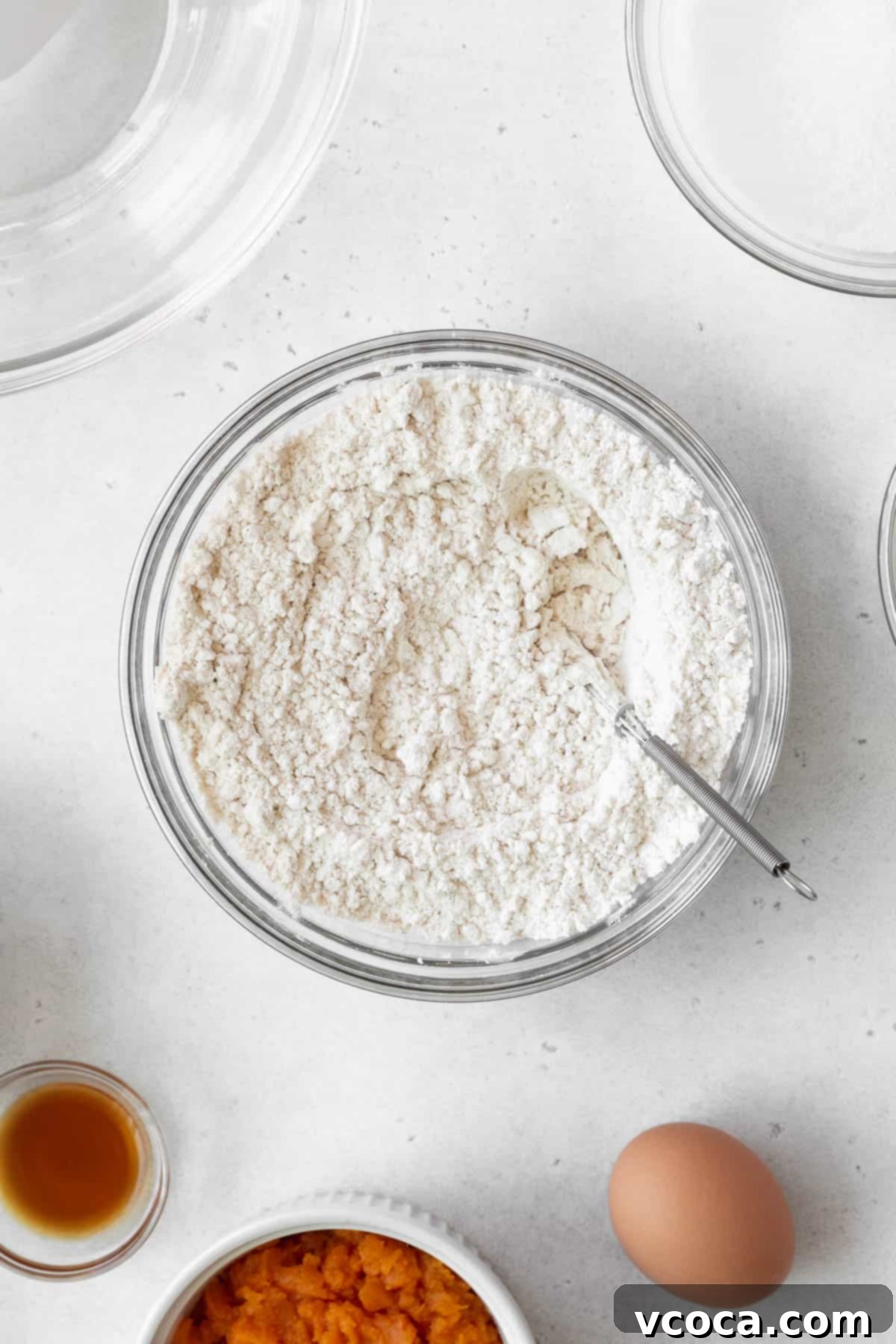 Spiced Sweet Potato Cake with Cashew Frosting 7 Mixed dry ingredients in a glass bowl.