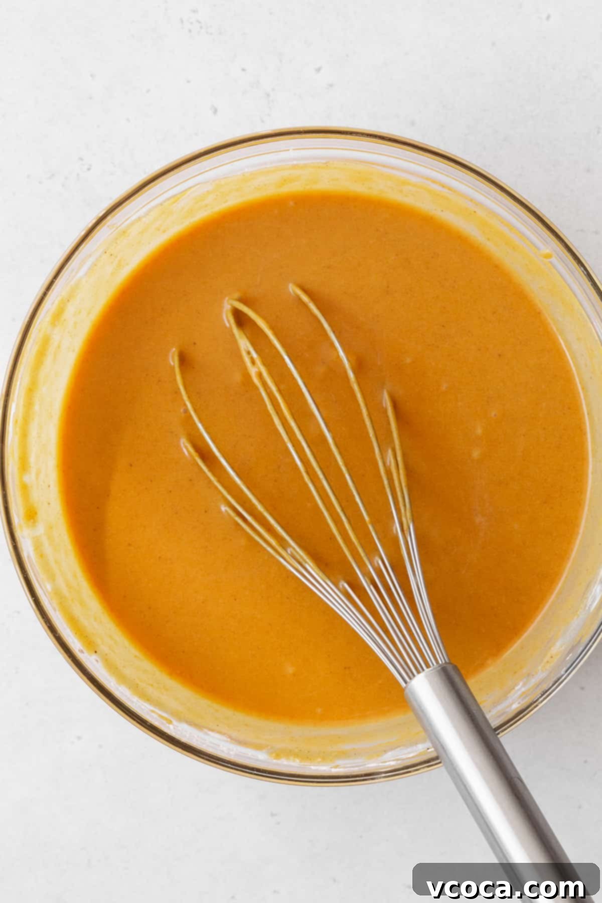 Decadent Vegan Pumpkin Pie 7 Vegan pumpkin pie filling in a bowl with a whisk.