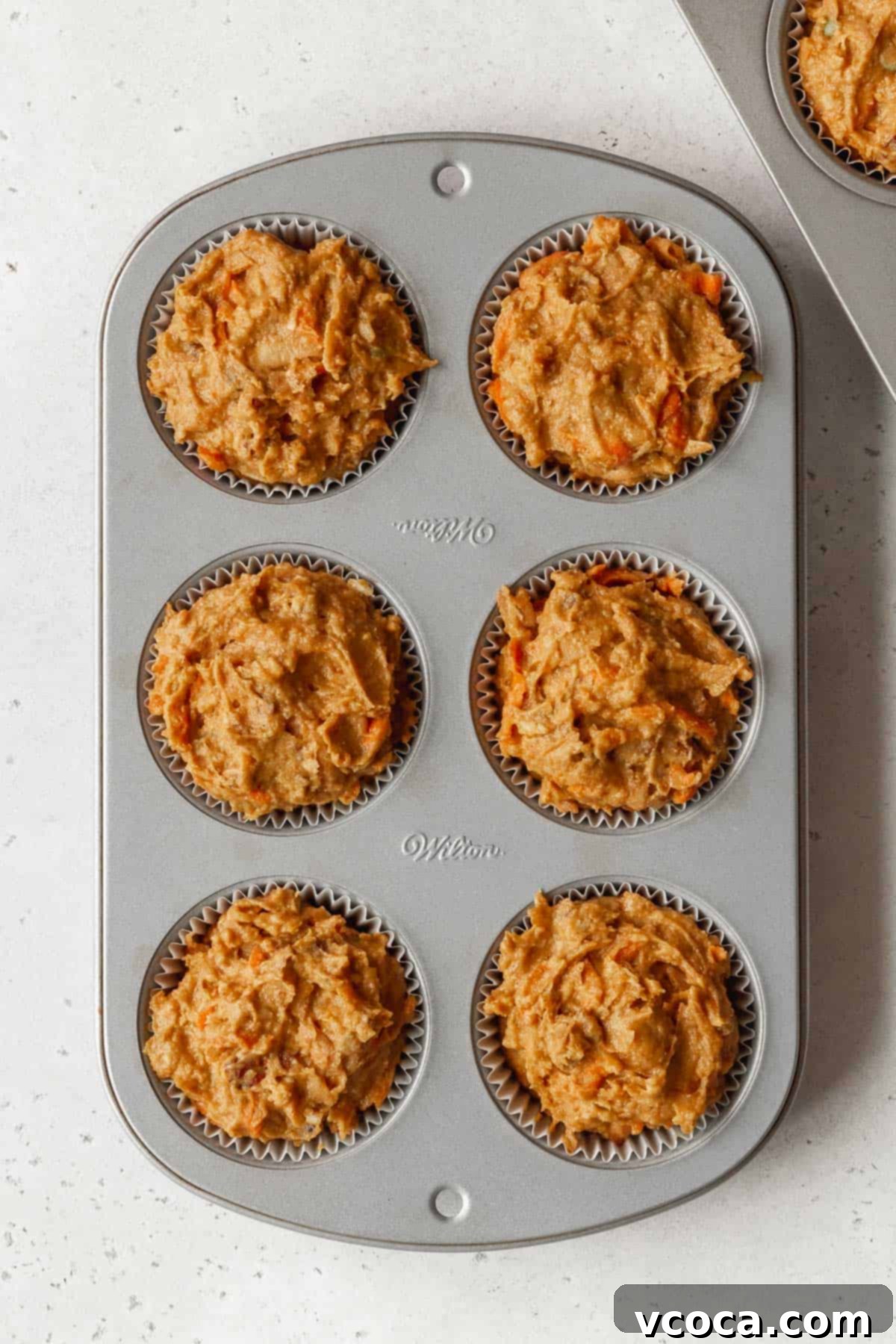 Vibrant Morning Glory Muffins Healthy Gluten Free 12 Process shot showing a 6-cup muffin tin with liners filled evenly with morning glory muffin batter, ready for baking.