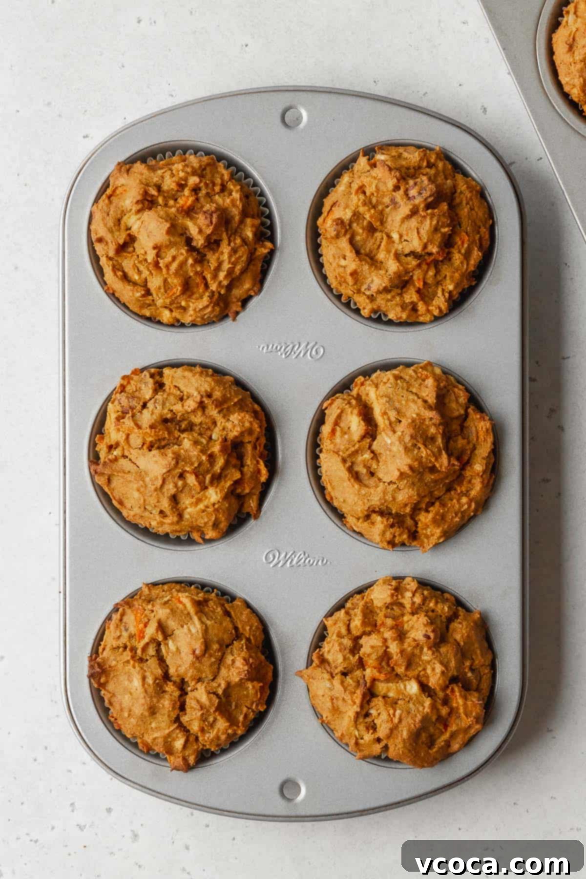 Vibrant Morning Glory Muffins Healthy Gluten Free 13 Process shot of golden brown pumpkin morning glory muffins cooling in the muffin tin immediately after baking.