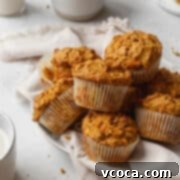 Vibrant Morning Glory Muffins Healthy Gluten Free 15 Square image of a pile of healthy morning glory muffins on a white plate, showcasing their rustic, wholesome appearance.