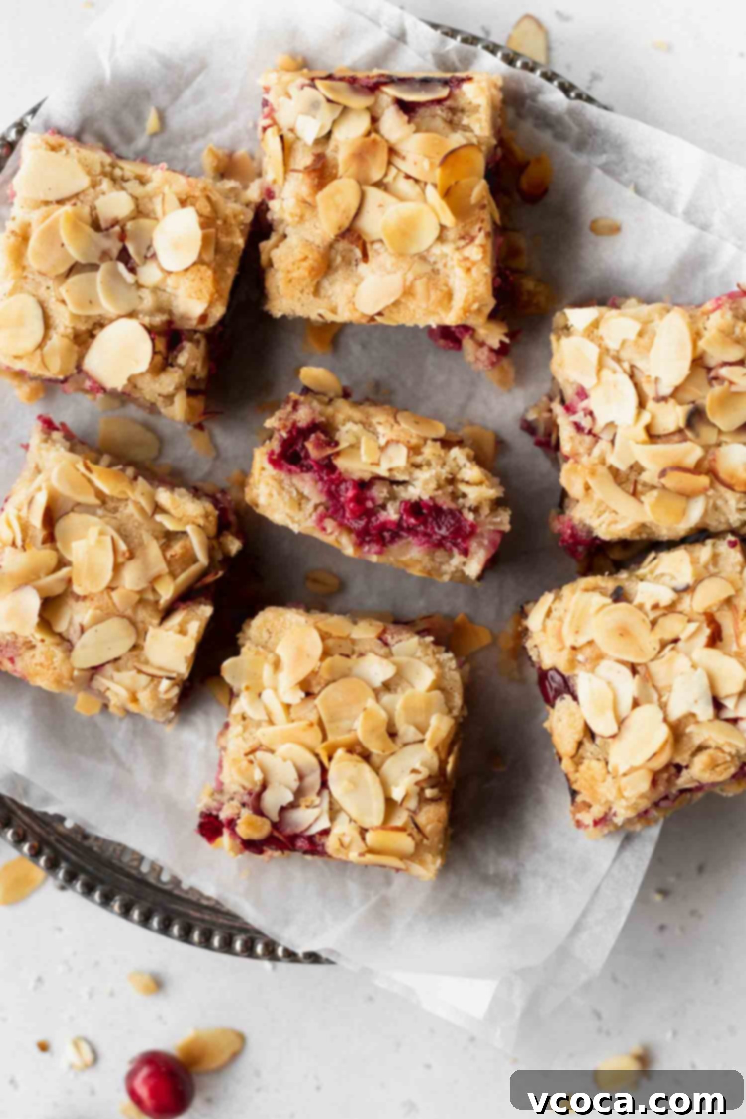 Gluten Free and Dairy Free Cranberry Oat Bars 5 Close-up of a gluten-free and dairy-free cranberry oat bar, showing the sliced almonds on top and the filling.