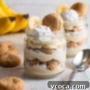 Creamy Vegan Banana Pudding 5 Two jars of vegan banana pudding with bananas in the background.