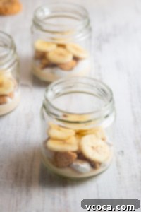 Bananas layered into a jar with cream and nilla wafers.