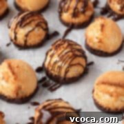 Heavenly Vegan Coconut Macaroons 13 Plain and chocolate drizzled vegan coconut macaroons on a white surface.