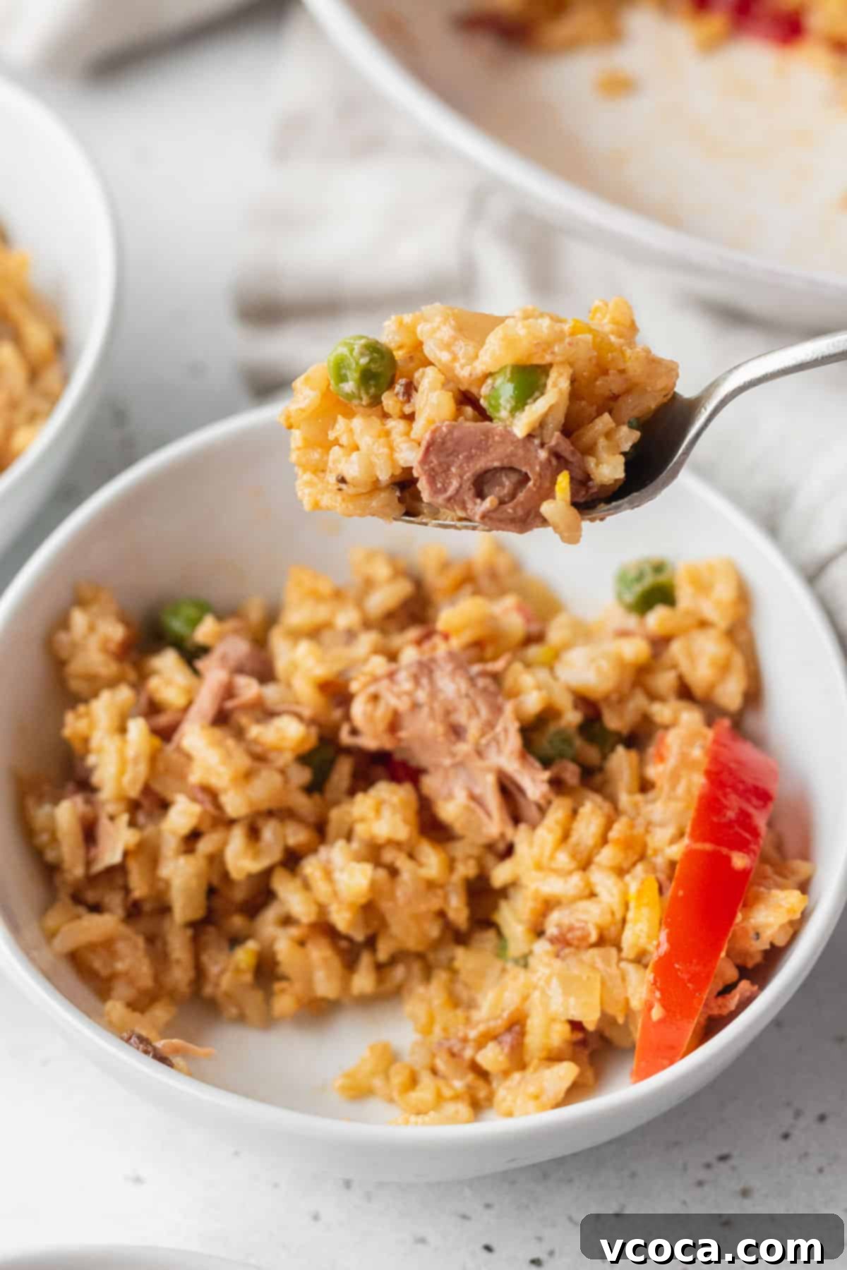 Flavorful Vegan Arroz Valenciana 15 A close-up shot of a spoonful of vegan Filipino paella, known as Arroz Valenciana, being delicately lifted from a bowl, highlighting its textures and vibrant ingredients.