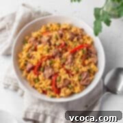 Flavorful Vegan Arroz Valenciana 16 Overhead shot of vegan Arroz Valenciana in a white bowl with a spoon and natural linen.