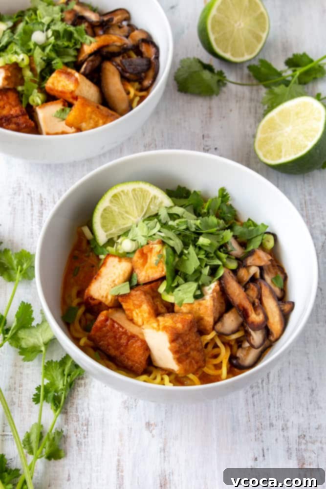 Quick and Easy Vegan Thai Red Curry Ramen 3 Close-up of creamy vegan Thai red curry ramen in a bowl with tofu and mushrooms.