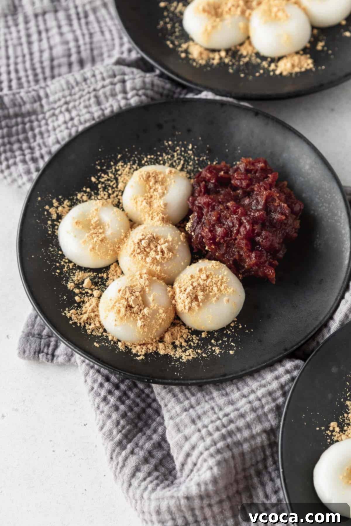 Pearl Rice Dumplings 15 5 shiratama dango on a black plate with kinako and anko paste.
