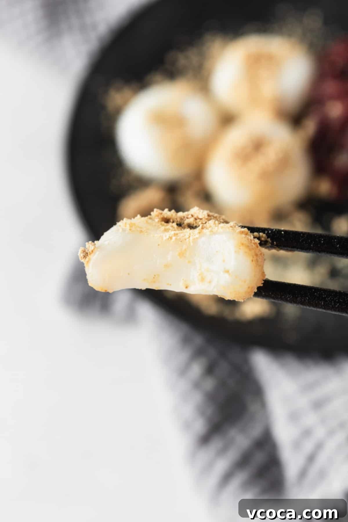 Pearl Rice Dumplings 17 A bitten shiratama mochi being held by black chopsticks.