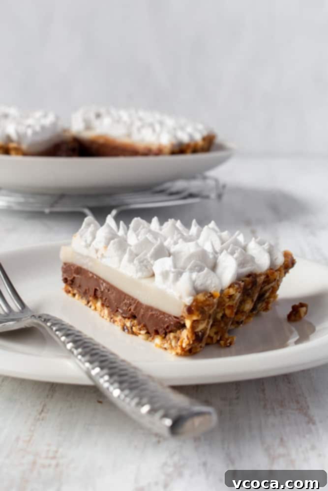 A perfectly sliced piece of vegan chocolate haupia pie on a white plate, showcasing its distinct layers of chocolate and coconut haupia, ready to be enjoyed.