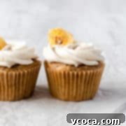 Vegan banana cupcakes topped with creamy vegan buttercream frosting, garnished with a banana slice.