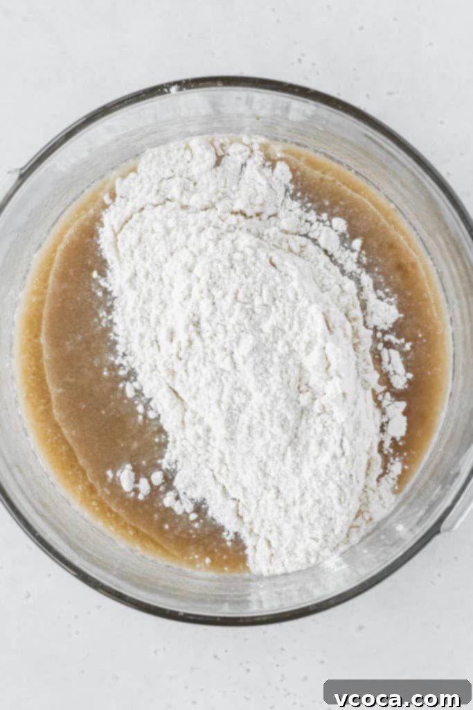 The combined wet and dry ingredients forming a smooth batter for banana cupcakes in a mixing bowl.