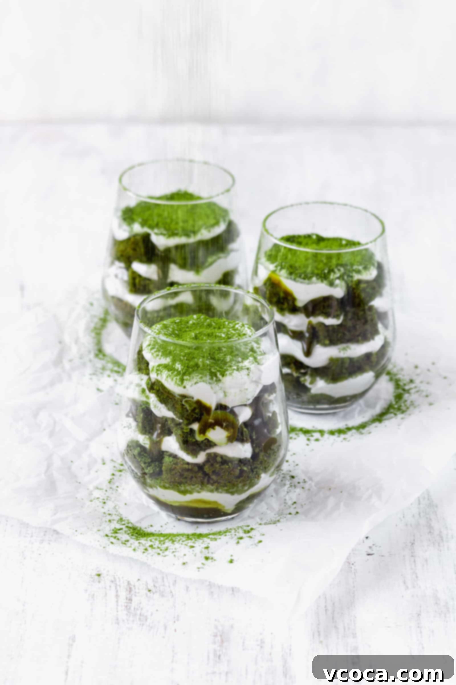 Effortless Plant-Based Matcha Tiramisu 3 Close-up of a single serving of Vegan Matcha Tiramisu in a glass, highlighting the distinct layers of green cake and white cream.