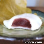 A square shot of kashiwa mochi with red bean filling with a bite taken out.