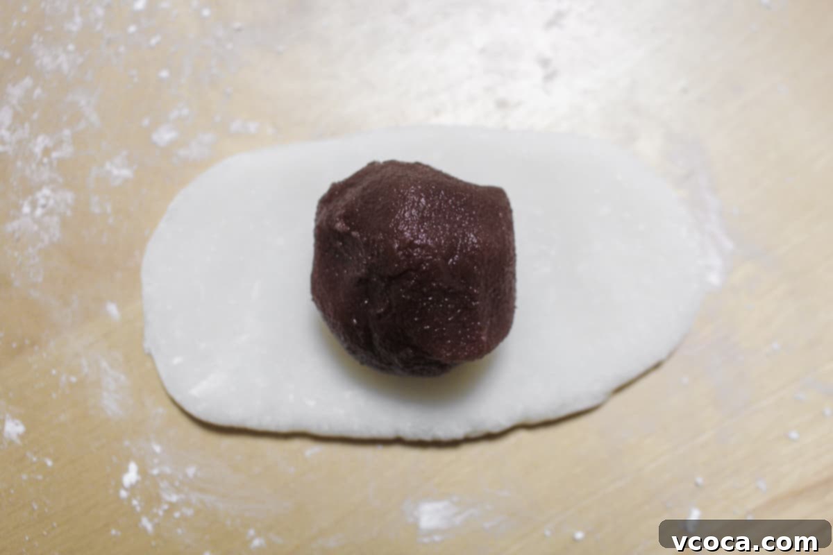 Red bean paste added to the center of the rolled out mochi.