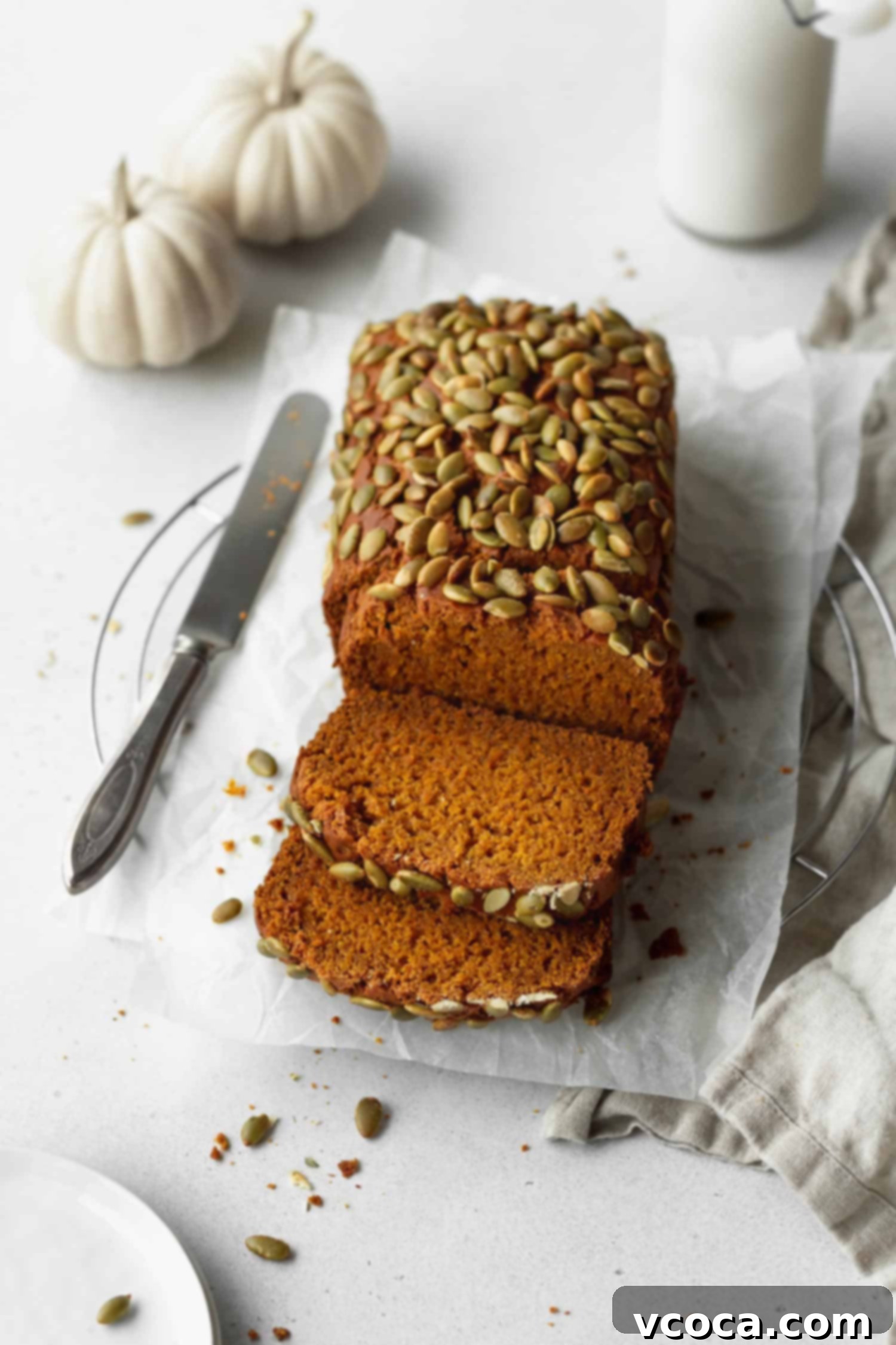 A beautifully sliced loaf of super moist gluten-free pumpkin bread, showcasing its rich orange hue and fluffy texture.