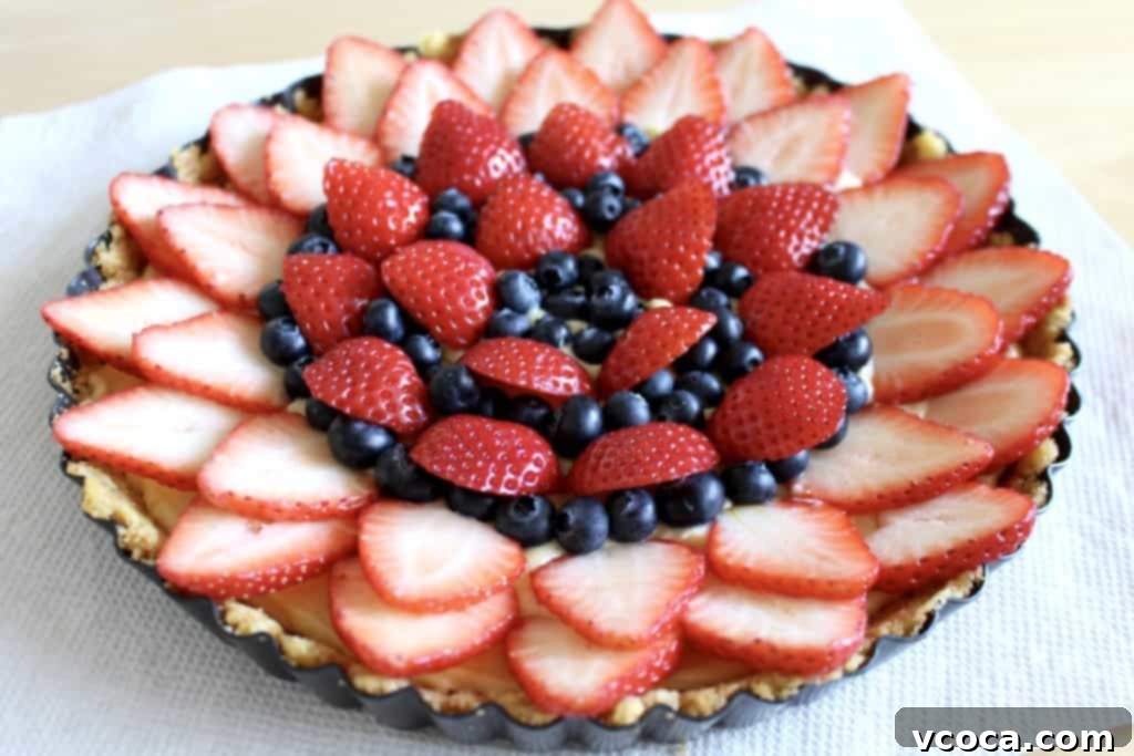 Luscious Strawberry and Blueberry Tart 8 Arranging fresh strawberries and blueberries on a tart