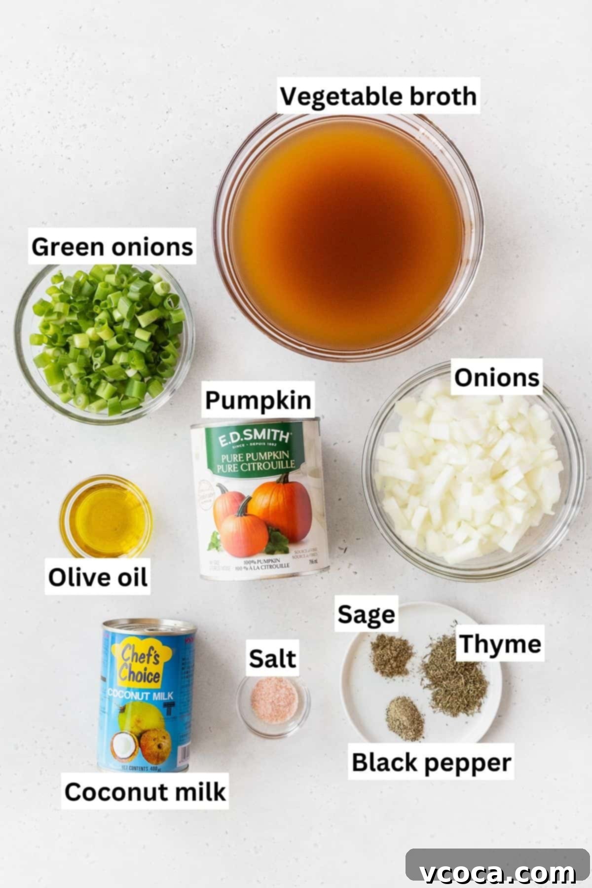 Velvety Vegan Pumpkin Soup 3 Ingredients needed to make vegan pumpkin bisque soup measured out into bowls on a white table with text overlay.