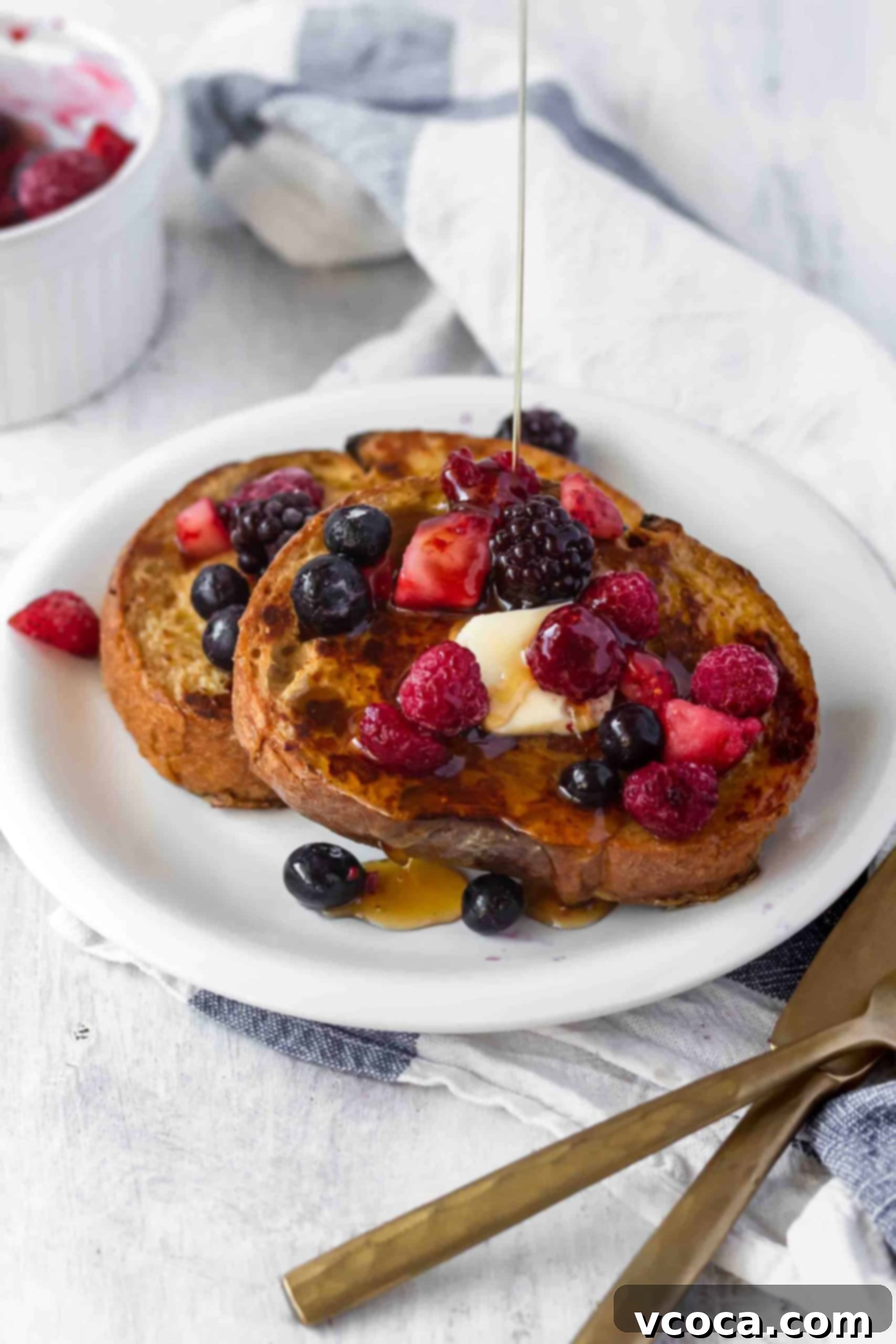 Effortlessly Delicious Vegan French Toast 4 A stack of perfectly cooked golden-brown vegan French toast slices, topped with a generous drizzle of maple syrup and powdered sugar, ready to be served.