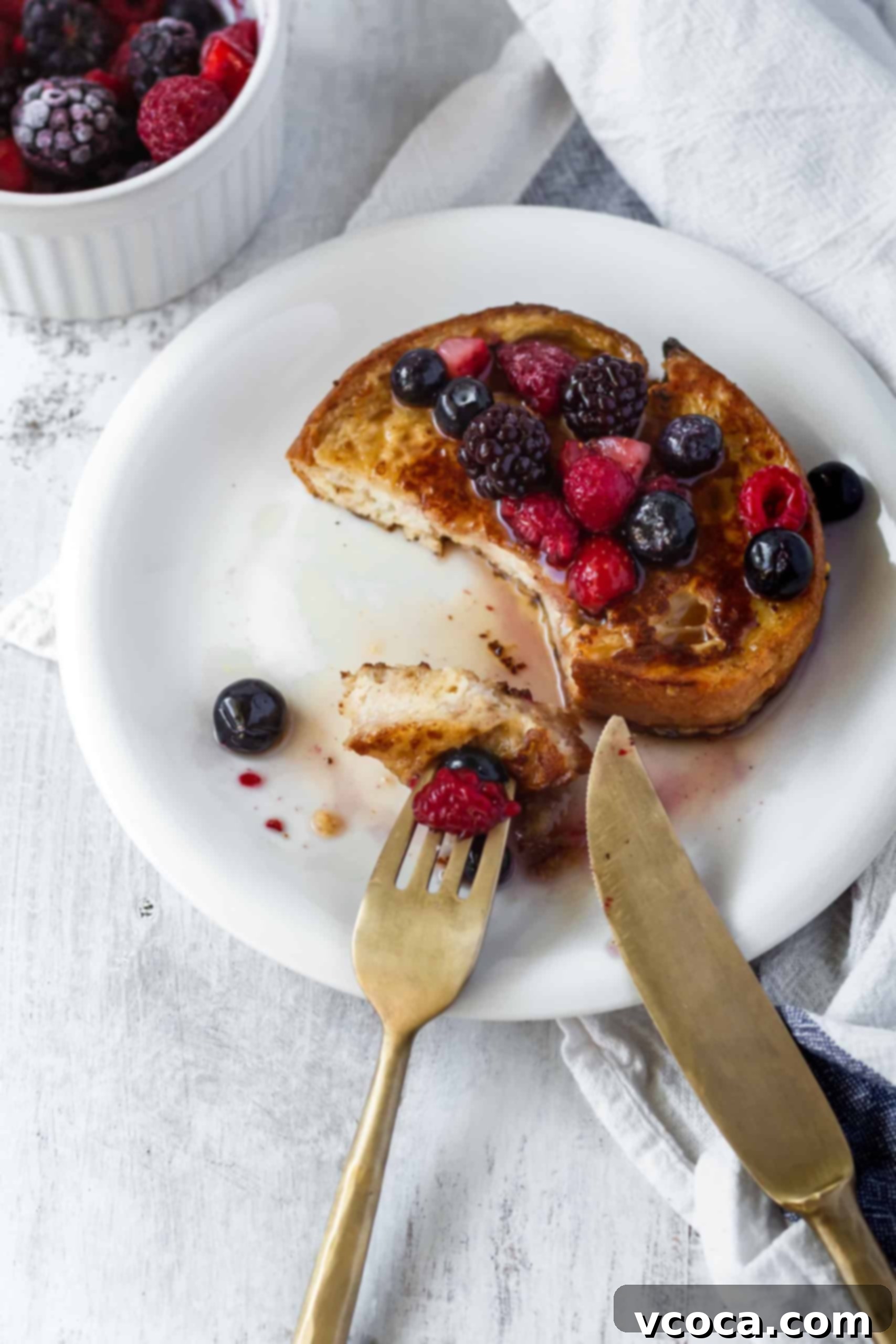 Effortlessly Delicious Vegan French Toast 5 A perfectly cooked slice of vegan French toast, golden brown and fluffy, being transferred from a nonstick skillet onto a wire rack to cool slightly before serving.