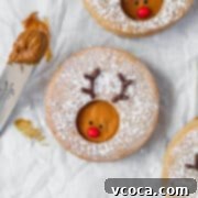 Rudolph's Holiday Reindeer Cookies 8 A reindeer cookie on a white surface next to a spatula with some cookie butter.